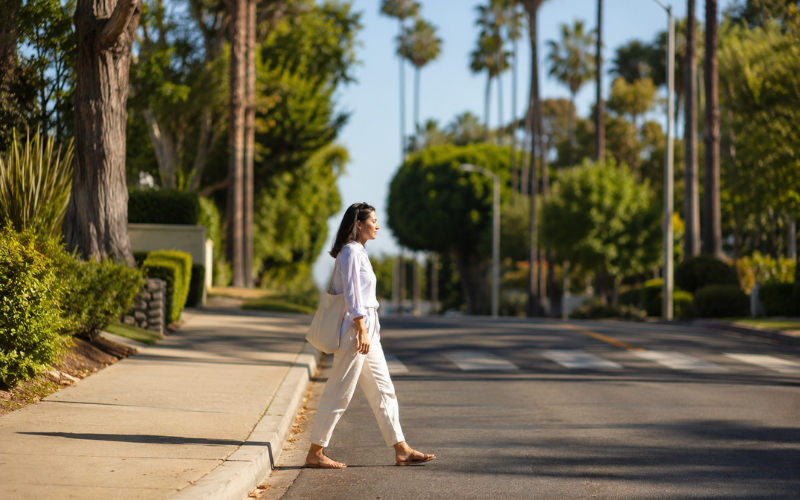 Woman safely crossing a quiet residential California street — is jaywalking legal in California under the Freedom to Walk Act AB 2147