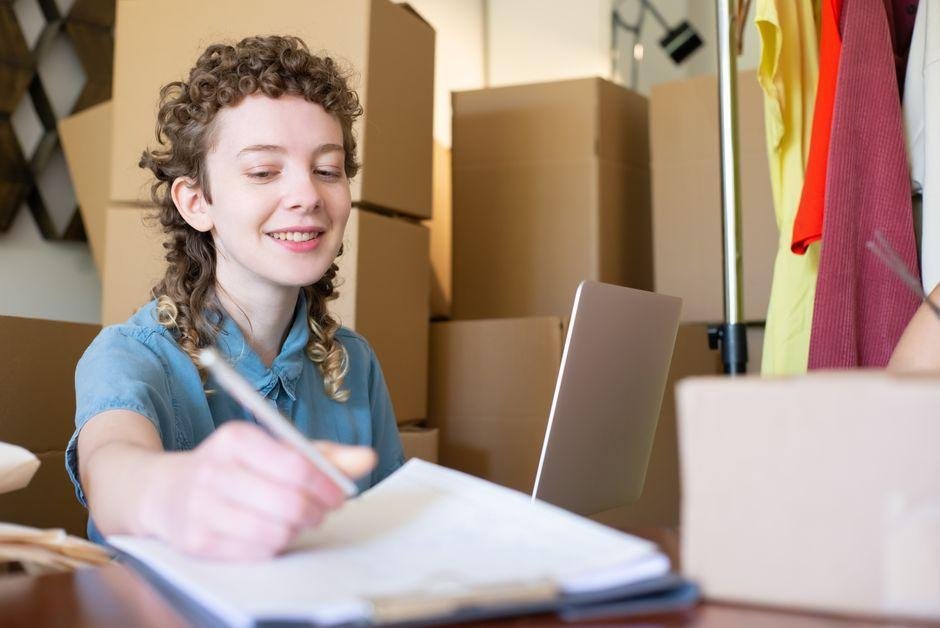 Small business owner reviewing financial documents while working from a home office.