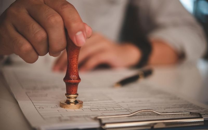 Person stamping an official document for FBI background check apostille and international document authentication.