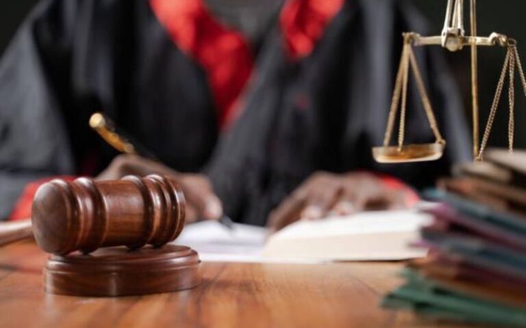Legal professional in robe signing documents representing the esquire meaning