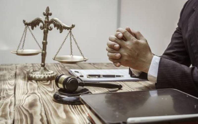 Attorney reviewing documents before a legal deposition with scales of justice and gavel